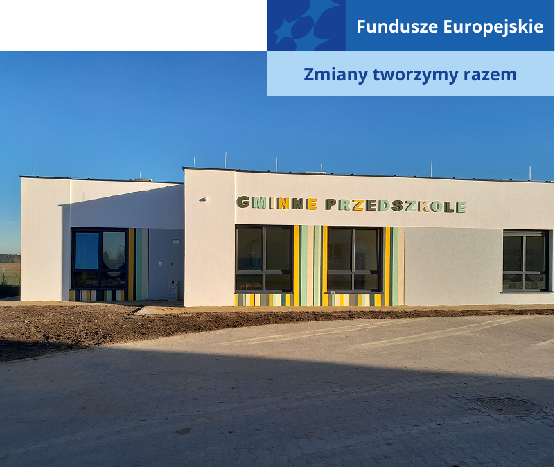 Zdjęcie przedstawia gmach nowego przedszkola. To parterowy budynek z kolorowym napisem „gminne przedszkole”. Fotografia pochodzi z archiwum beneficjenta.