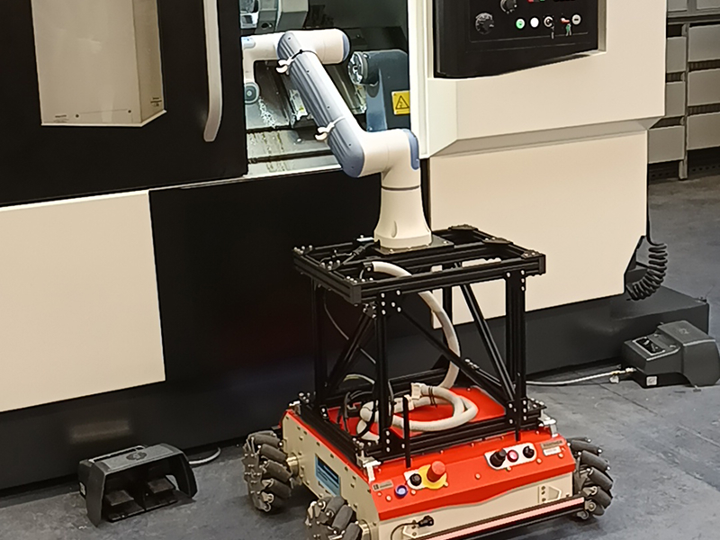 Fotografia ukazuje wyposażenie laboratorium maszyn inteligentnych. Widoczne jest między innymi ramię robotyczne, chwytak, kamera, tokarka sterowana numerycznie i platforma jezdna. Zdjęcie pochodzi z archiwum Urzędu Marszałkowskiego Województwa Wielkopolskiego.