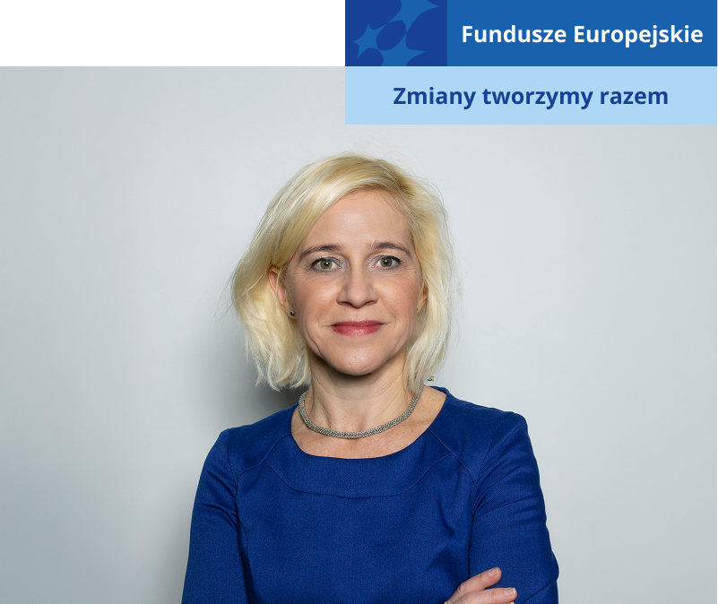 Na zdjęciu znajduje się profesor Agnieszka Niezgoda. Kobieta w średnim wieku, jasnych włosach i niebieskiej sukience, uśmiecha się. Fotografia pochodzi z archiwum prywatnego.
