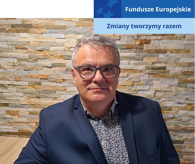 Zdjęcie przedstawia mężczyznę w średnim wieku, w okularach, koszuli i marynarce. Autorem fotografii jest Zuzanna Pyżalska.