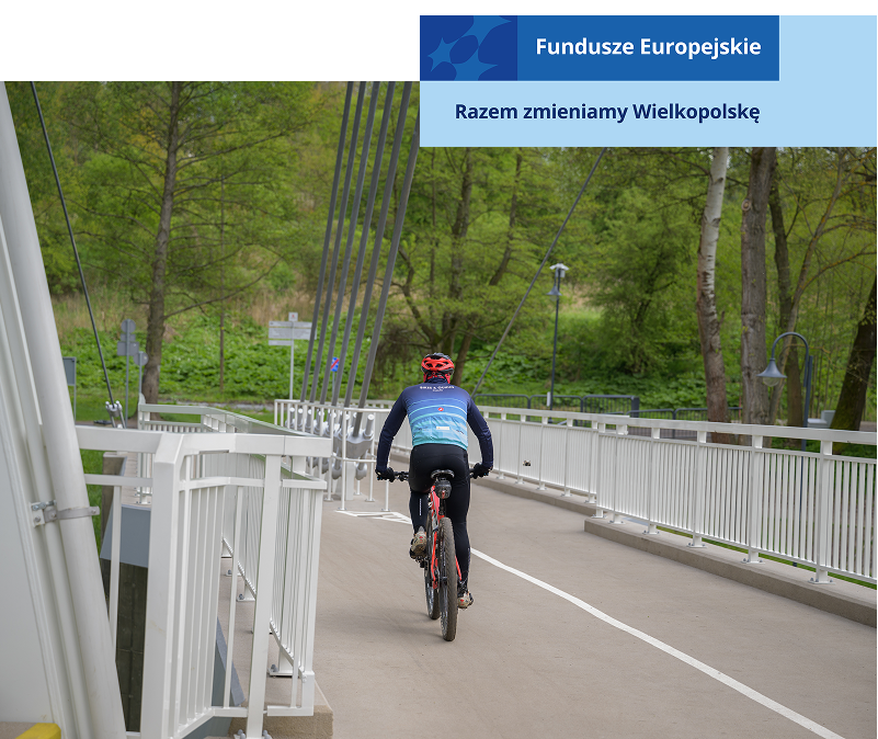 Na zdjęciu widoczny jest rowerzysta w kasku, przejeżdżający przez wiadukt. Autorem fotografii jest Maciej Motylewski.