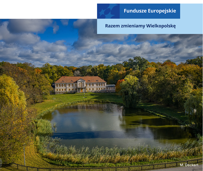 Zdjęcie przedstawia pałac, stojący wokół drzew. Przed budynkiem znajduje się staw. Autorem fotografii jest M. Deckert.