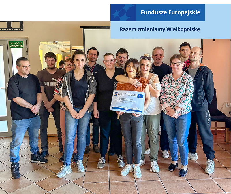 Zdjęcie przedstawia uczestników projektu unijnego. Grupa kilkunastu kobiet i mężczyzn pozuje, uśmiechając się. Fotografia pochodzi z archiwum archiwum Miejsko-Gminnego Ośrodka Pomocy Społecznej w Kępnie.