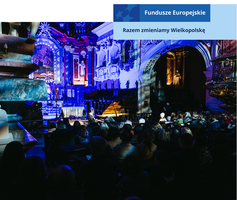 Zdjęcie przedstawia koncert fortepianowy odbywający się w kościele. Widoczne są imponujące zdobienia, figury. Solista zasiada przy fortepianie ustawionym przed ołtarzem. Publiczność znajduje się w dalszej części wnętrza. Pomieszczenie skąpane jest w ciemnych i niebieskich barwach. Fotografia pochodzi z archiwum beneficjenta.