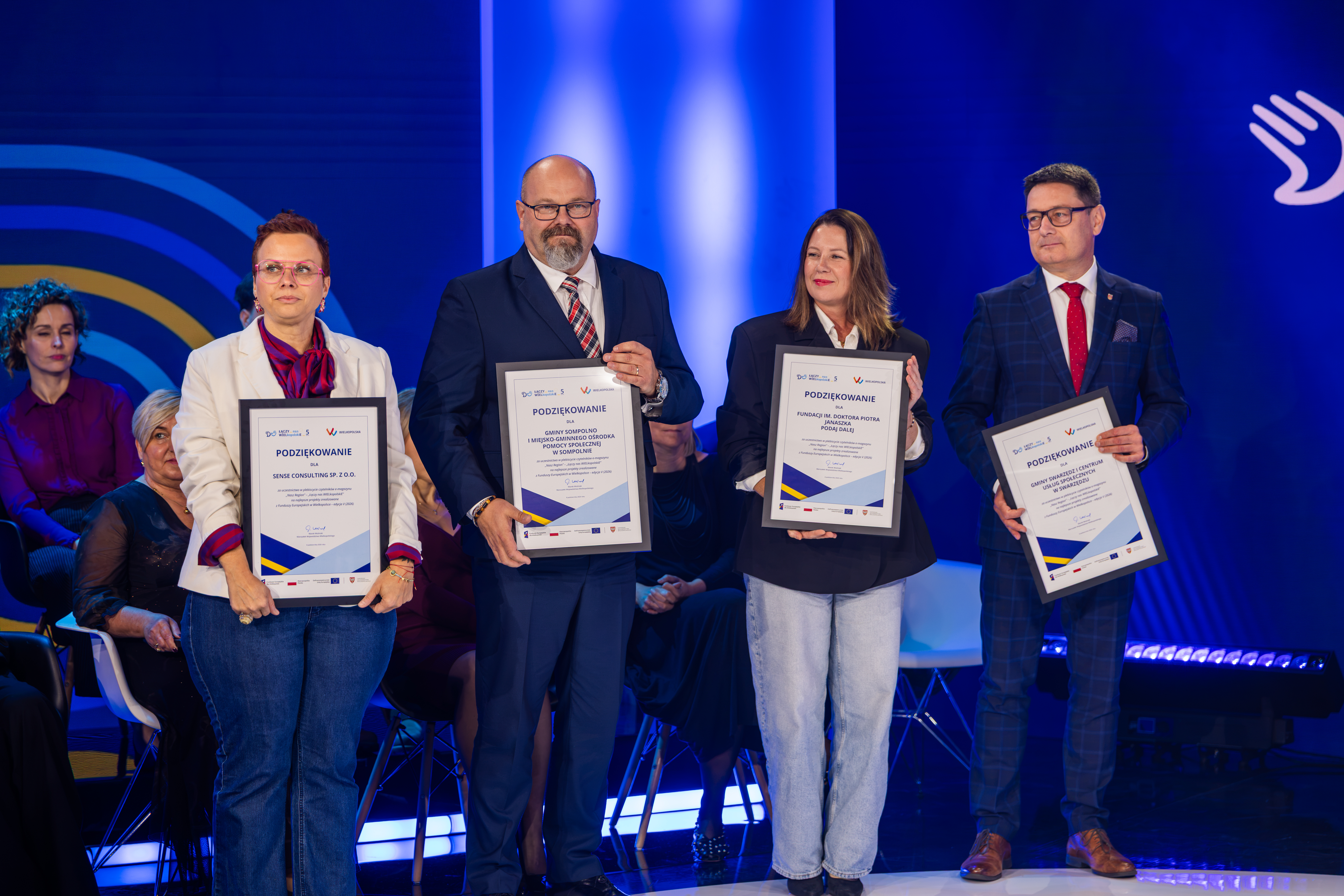 Na zdjęciu cztery osoby trzymające w rękach podziękowania 