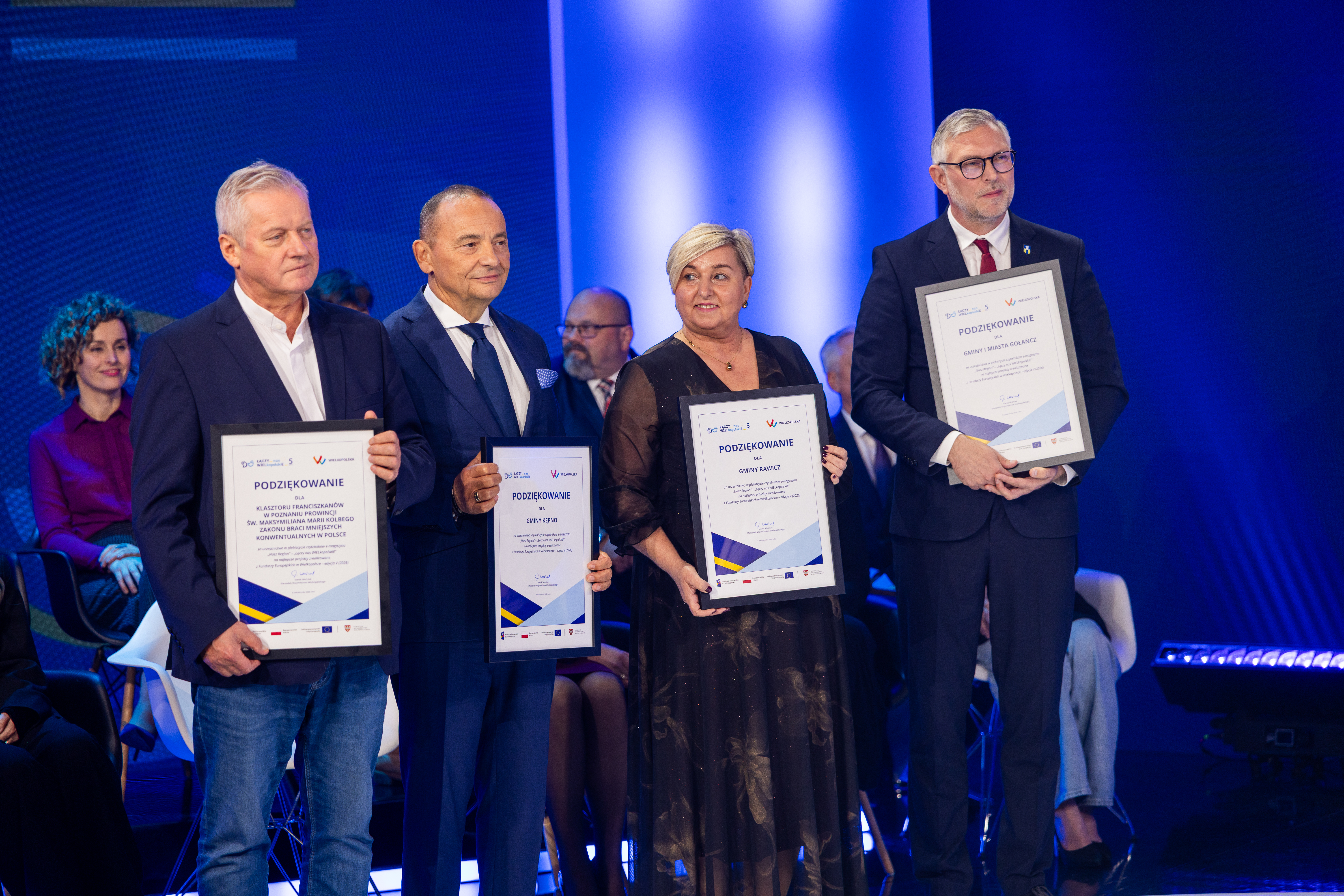 Na zdjęciu cztery osoby trzymające w rękach ramki z podziękowaniami