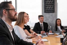 grupa ludzi siedzi w sali na spotkaniu