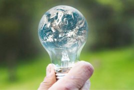 Żarówka, w której odbija się obraz planety ziemi 