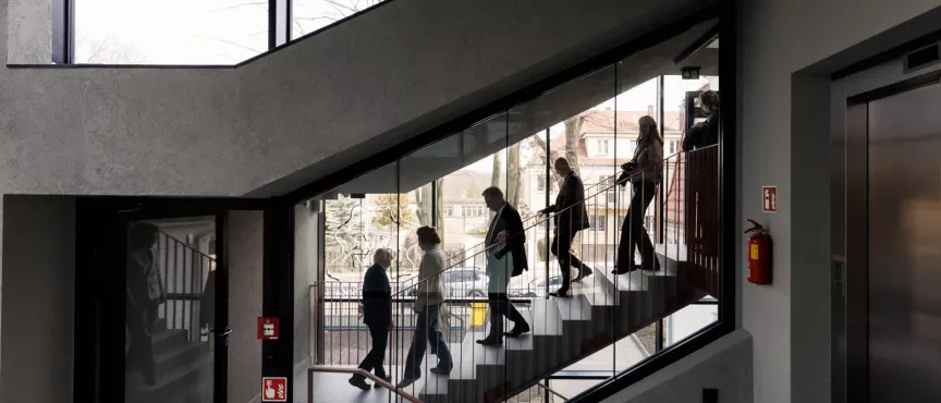 Wygląd wnętrz budynków, z oddali widać schodzące po schodach osoby 