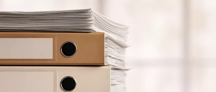 Na obrazku 4 segregatory dokumentów ułożone jeden na drugim.