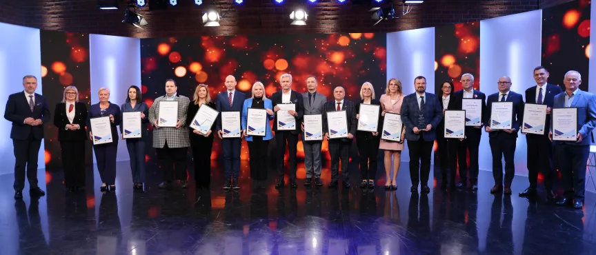 Na zdjęciu kilkanaście osób trzymających w rękach ramki z podziękowaniami 