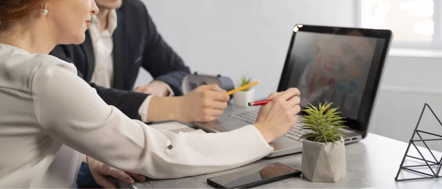 dwie osoby siedzą przy komputerze