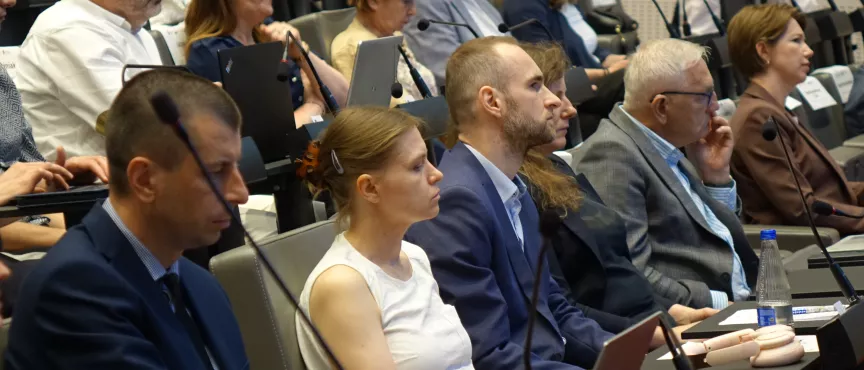 Na zdjęciu kilka osób przysłuchujących się rozmowie 