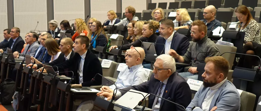 Na zdjęciu widać kilkanaście osób siedzących na widowni sali sesyjnej 