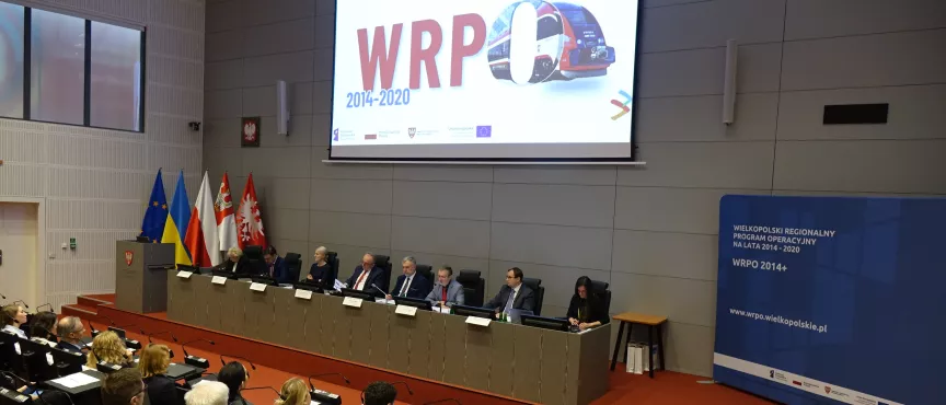 Na zdjęciu widok na stół prezydialny, nad nim napis WRPO