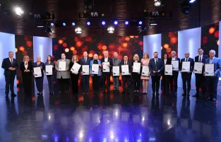 Na zdjęciu kilkanaście osób trzymających w rękach ramki z podziękowaniami 