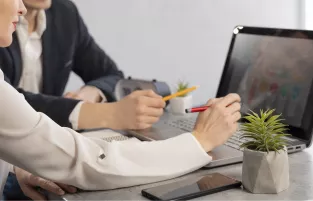 dwie osoby siedzą przy komputerze