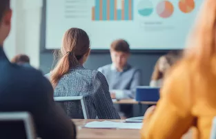 grupa ludzi siedzi w sali na spotkaniu