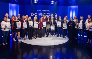 Na zdjęciu widać kilkanaście osób, w tle napis gala plebiscytu "Łączy nas WIELkopolskiE"