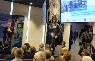 Na zdjęciu jeden mężczyzna, który przemawia do publiczności 