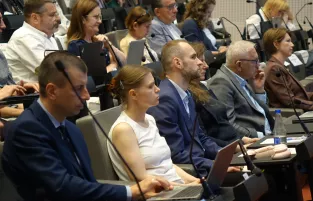 Na zdjęciu kilka osób przysłuchujących się rozmowie 