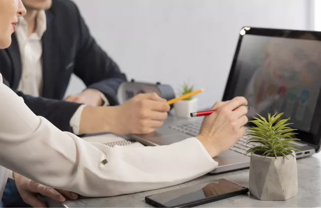 dwie osoby siedzą przy komputerze