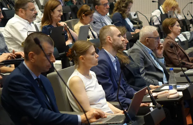 Na zdjęciu kilka osób przysłuchujących się rozmowie 