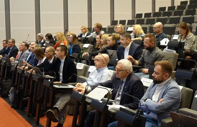 Na zdjęciu widać kilkanaście osób siedzących na widowni sali sesyjnej 