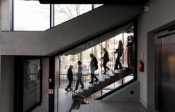 Wygląd wnętrz budynków, z oddali widać schodzące po schodach osoby 