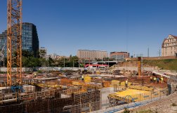 Na zdjęciu widok na teren budowy, w tle wieżowiec i inne budynki w centrum Poznania 