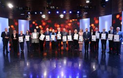 Na zdjęciu kilkanaście osób trzymających w rękach ramki z podziękowaniami 