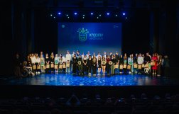 Na zdjęciu kilkanaście osób stojących na scenie, w tle napis "kręcimy lepsze jutro"