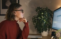 kobieta siedzi przed ekranem komputera