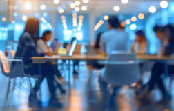 grupa osób siedzi w sali przy stole