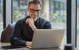 mężczyzna siedzi przy biurku przed komputerem