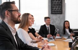 grupa ludzi siedzi w sali na spotkaniu