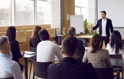 Grupa osób siedzących na sali