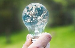 Żarówka, w której odbija się obraz planety ziemi 