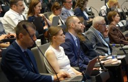 Na zdjęciu kilka osób przysłuchujących się rozmowie 