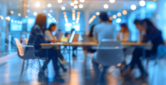 grupa osób siedzi w sali przy stole