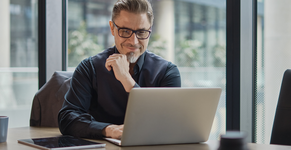 mężczyzna siedzi przy biurku przed komputerem