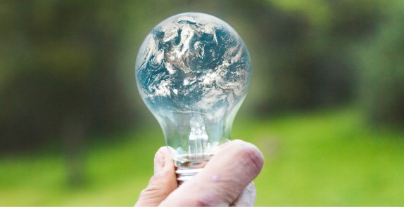 Żarówka, w której odbija się obraz planety ziemi 