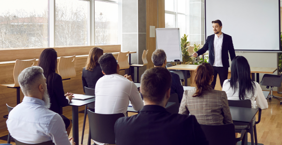 Grupa osób siedzących na sali