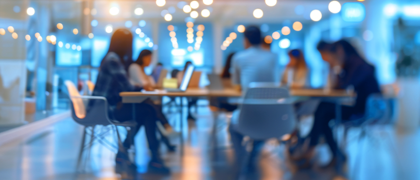 grupa osób siedzi w sali przy stole