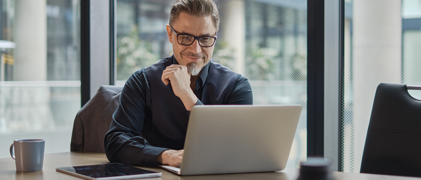 mężczyzna siedzi przy biurku przed komputerem