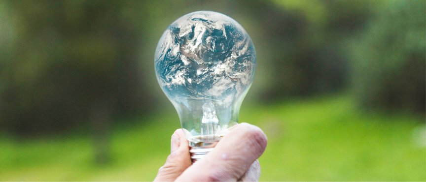 Żarówka, w której odbija się obraz planety ziemi 