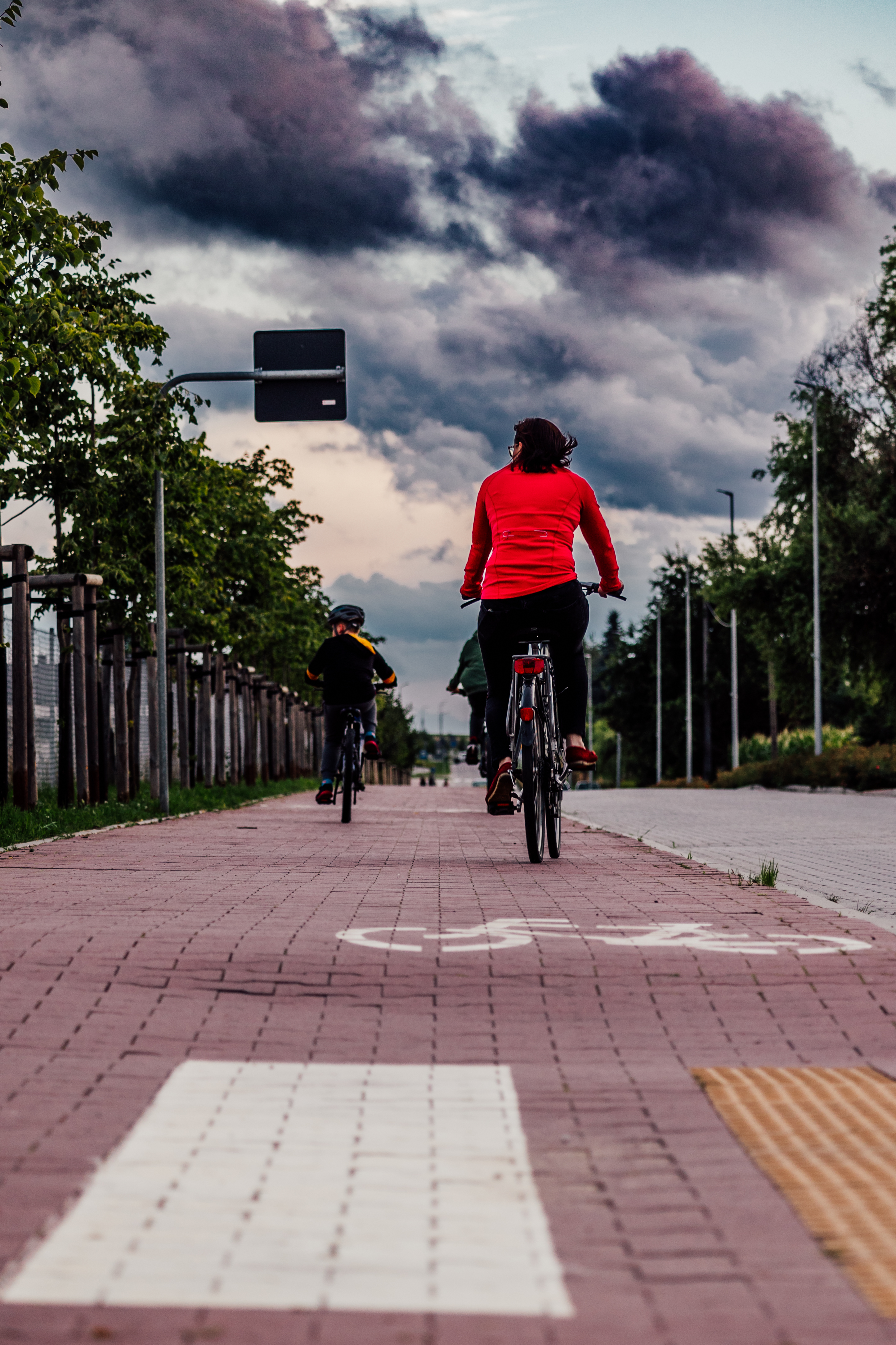 Widać dwóch rowerzystów, którzy jadą drogą rowerową 