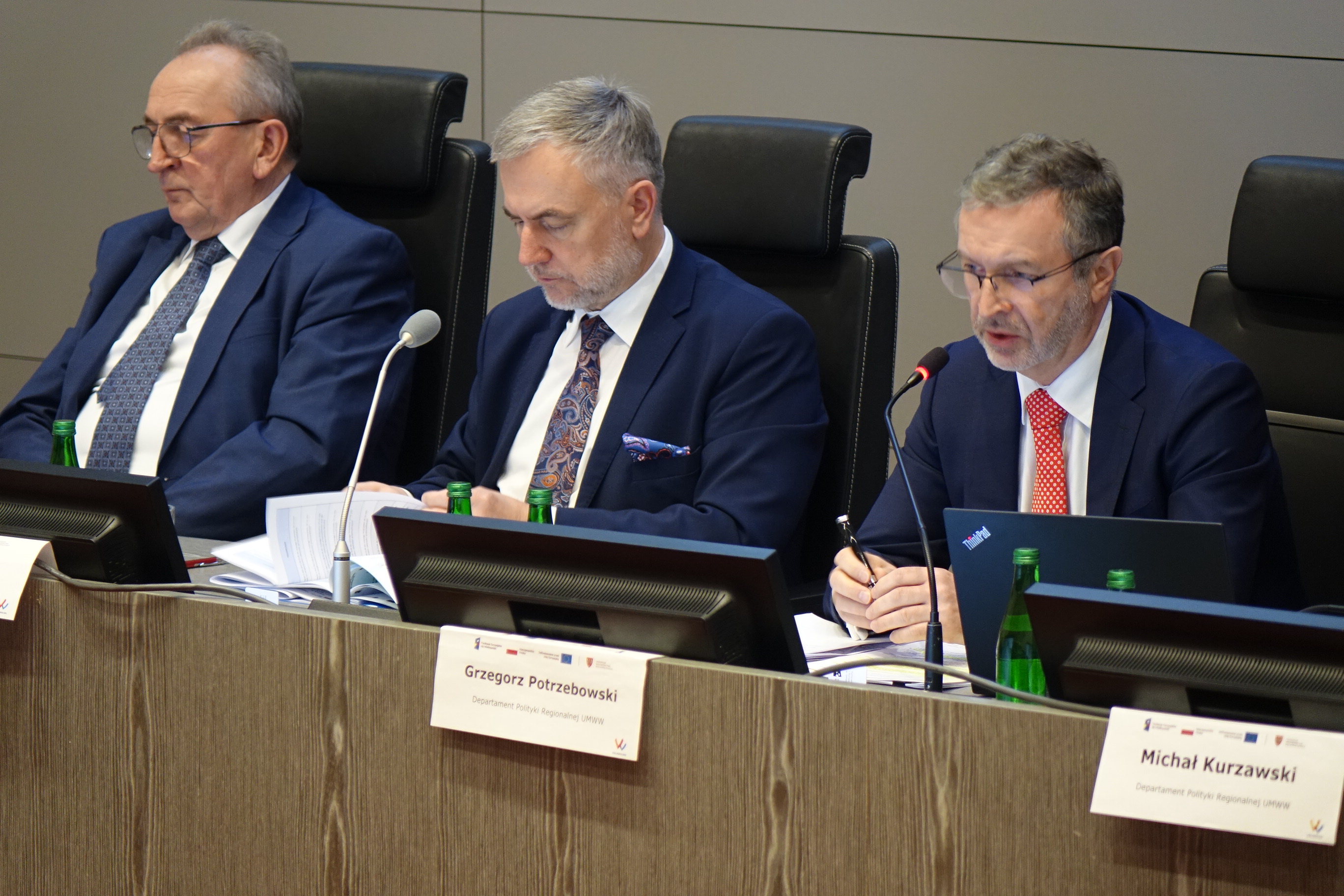 Na zdjęciu trzech mężczyzn ubranych w garnitury